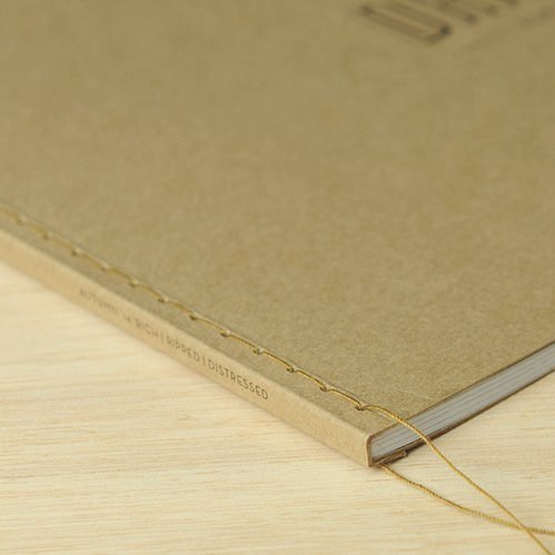 Hands sewing a notebook