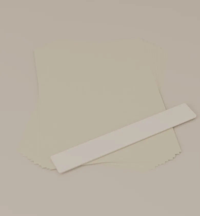 Uncoated 120gsm sheets fanned out beside a bone folder